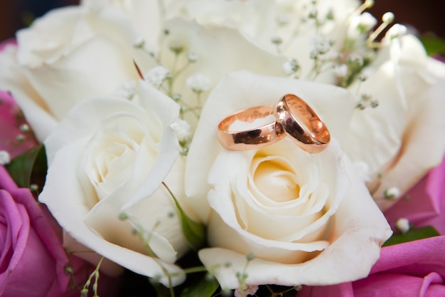 Gouden trouwringen op bloemen