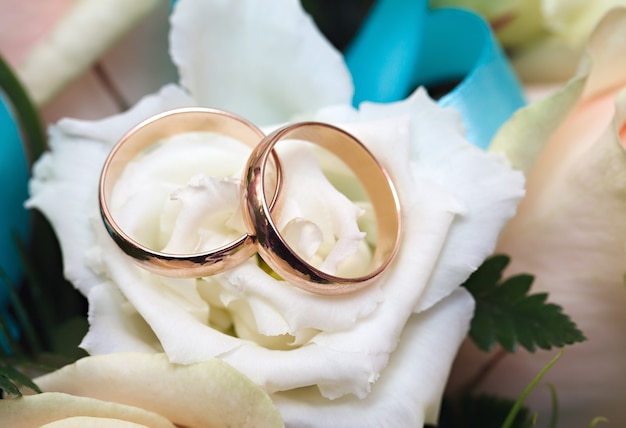 Gouden trouwringen op een boeket bloemen voor de bruid