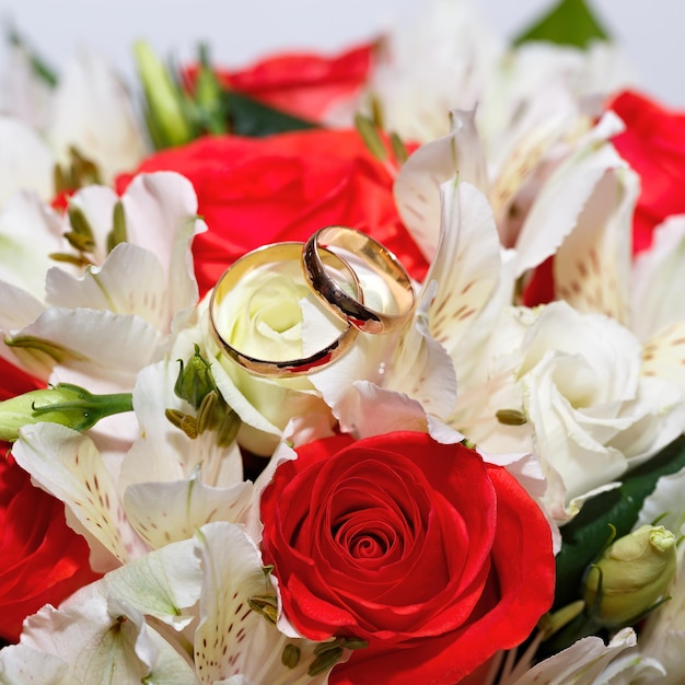 Gouden trouwringen op een boeket bloemen voor de bruid