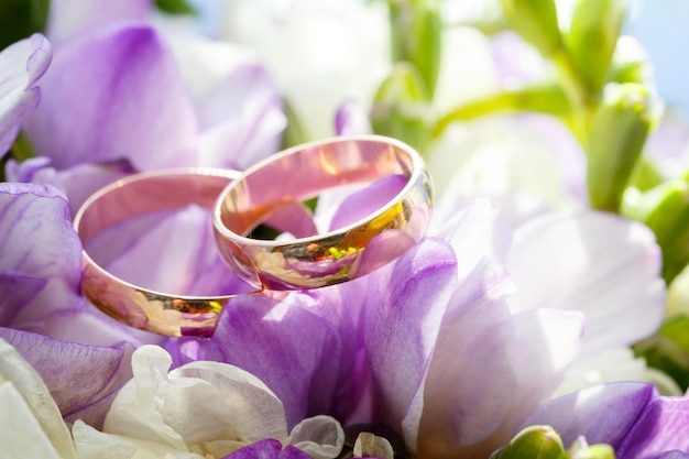 Gouden trouwringen op een boeket bloemen voor de bruid