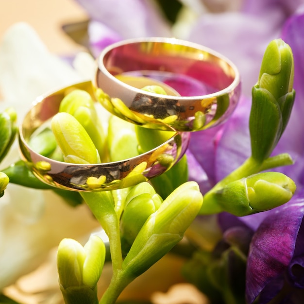 Gouden trouwringen op een boeket bloemen voor de bruid