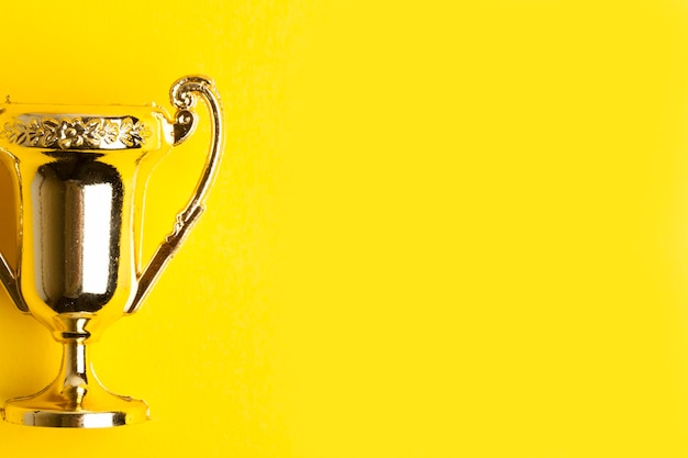 Foto gouden winnaars prestatie trofee op een gele achtergrond