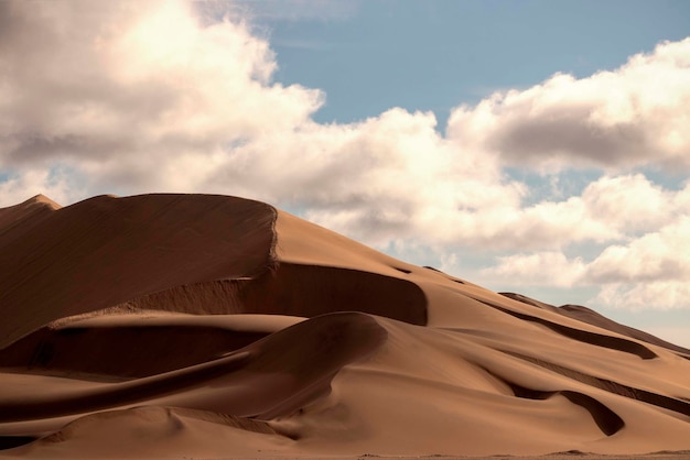 Gouden zandduin 7 en witte wolken op een zonnige dag in de Namib-woestijn.