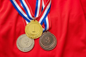 Gouden, zilveren en bronzen medailles op de achtergrond van het rode shirt winnaars van sportatleten