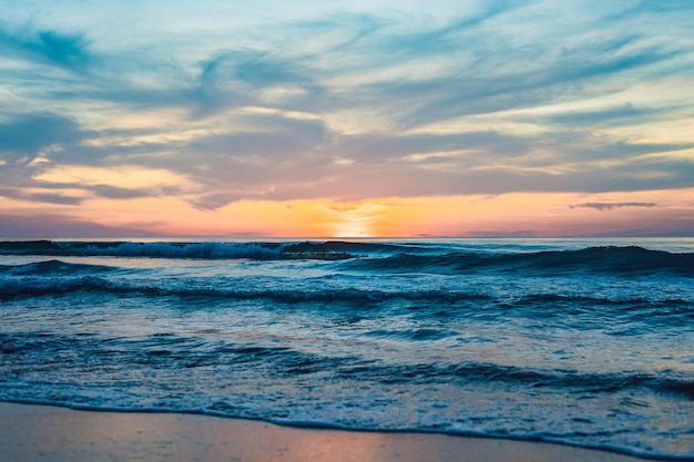 Gouden zonsondergang over het strand met golfspatten in de zomer van Thailand