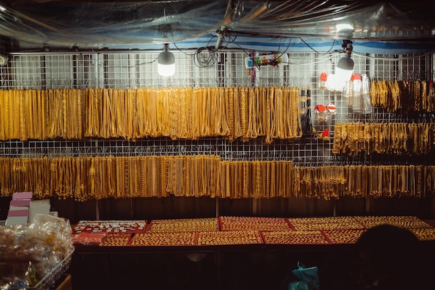 Goudmarkt in de juwelierswinkel van het paneelgoud in Bangkok voor de verkoper die producten en gouden showcase aanbeveelt