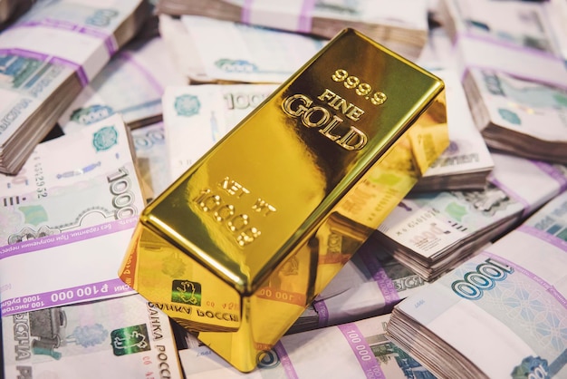 Goudstaaf op Russische geldachtergrond 1000 roebelbankbiljetten goud en deviezenreserves