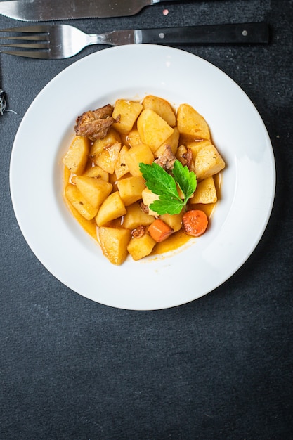 Foto carne di gulasch con patate, verdure in umido e maiale