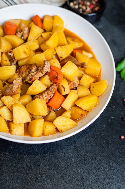 Goulashvlees met aardappelen, gestoofde groenten en varkensvlees