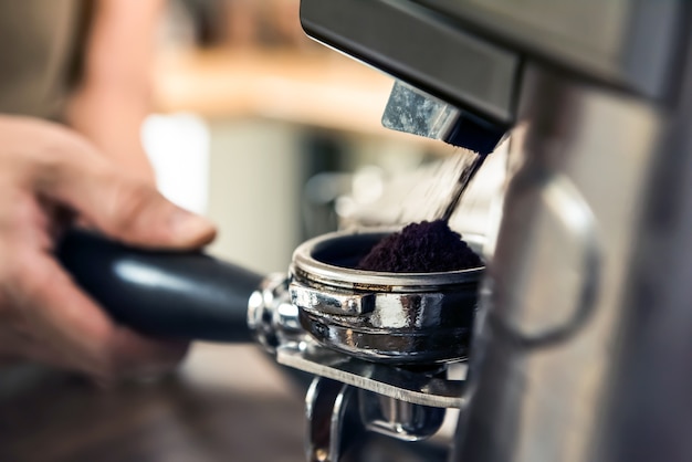 Gound coffee from grinder machine in portafilter basket