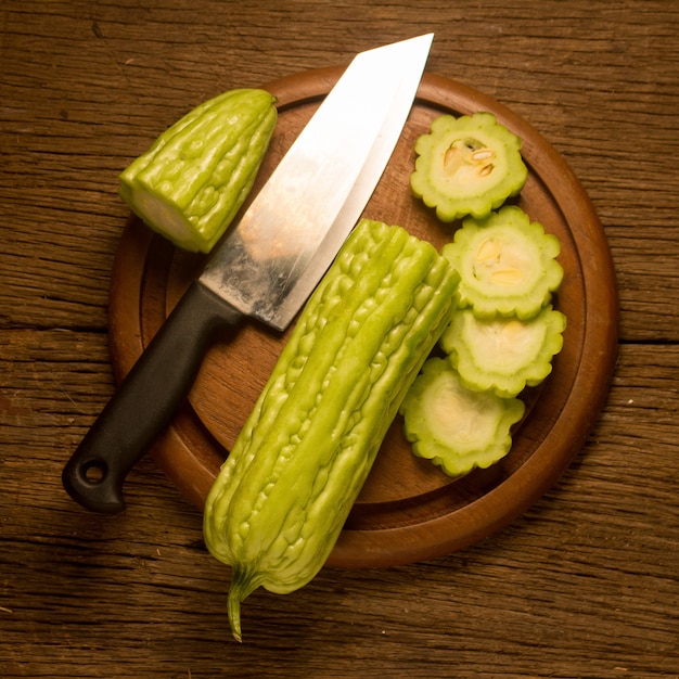 Gourd. bitter. on old wooden. and knife. cut. slice