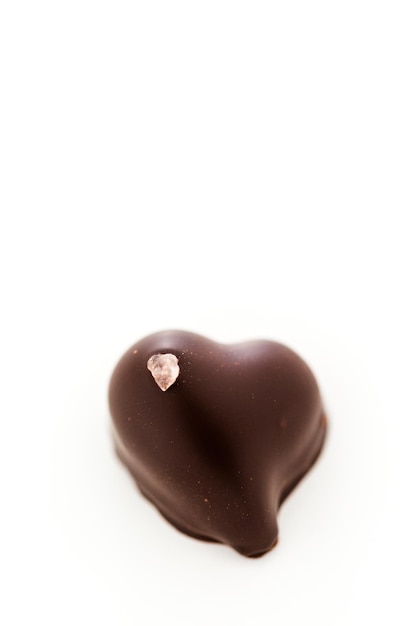 Gourmet 85% Coure d'Or chocolate truffles in heart shape on a white background.