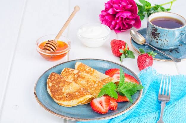 Gourmet breakfast. Delicious sweet fried pancakes with fresh strawberries.