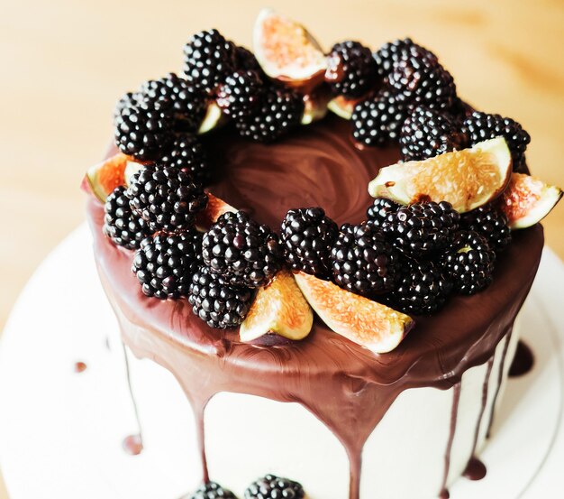 A gourmet cake drenched in chocolate and garnished with blackberries and figs Holiday sweets