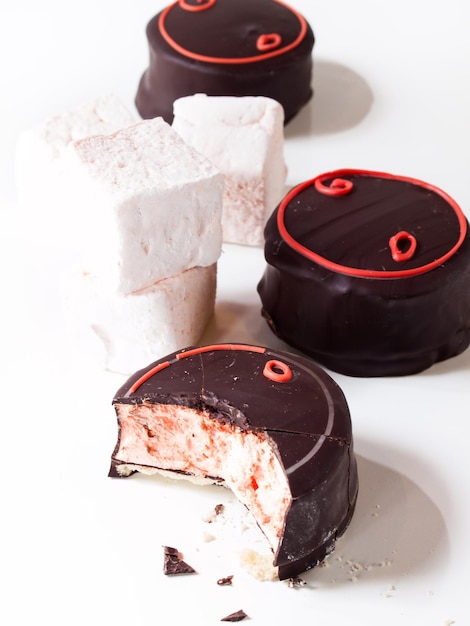 Gourmet chocolate covered blood orange marshmallows on white background.