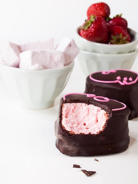 Gourmet chocolate covered strawberry marshmallows on white background.