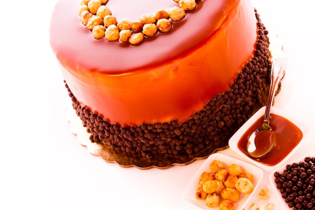 GOurmet chocolate, hazelnut, and caramel cake on white background.