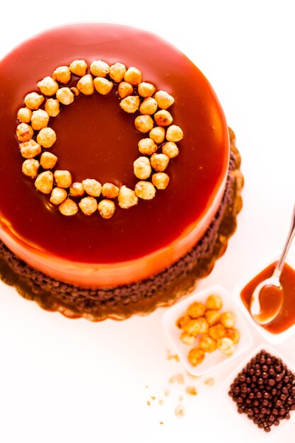 GOurmet chocolate, hazelnut, and caramel cake on white background.