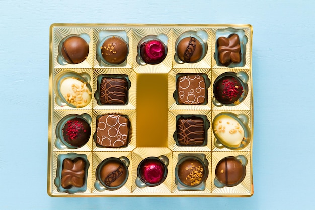 Gourmet chocolates in golden box on blue  back ground.