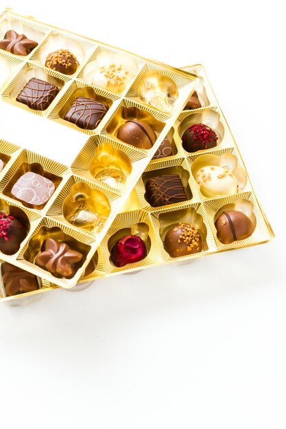 Gourmet chocolates in golden box on a white background.