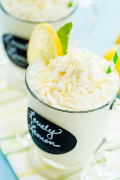 Gourmet cold lovely lemon chocolate drink garnished with white chocolate, lemon and mint.