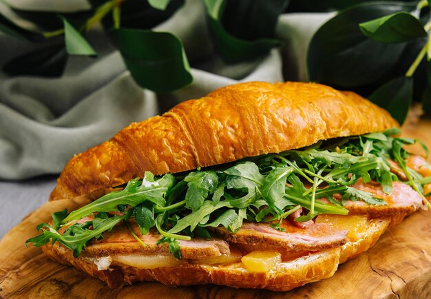 Foto sandwich croissant gourmet con pancetta e arugula