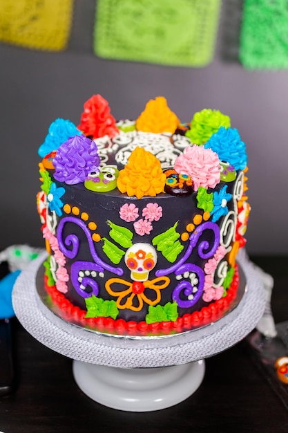 Gourmet Dia de los Muertos cake decorated with colorful buttercream frosting and gummy cupcake toppers.