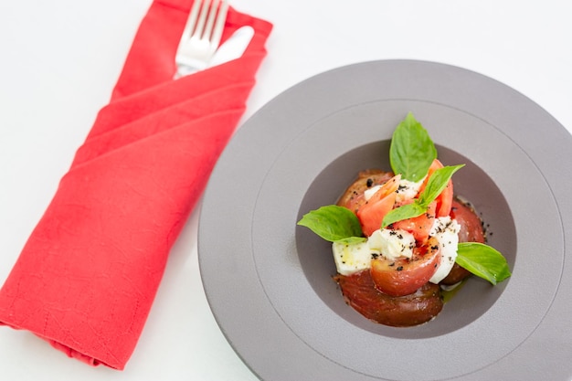 Gourmet food. Luxury restaurant background, white table top view and salad in grey bowl, red napkin