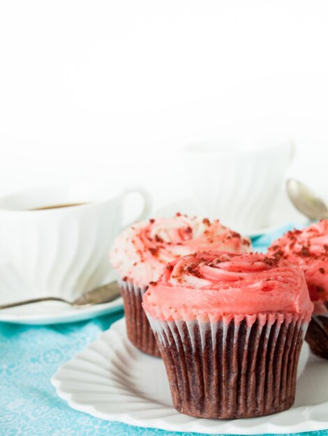 Gourmet red welveet cupcake on white plate.
