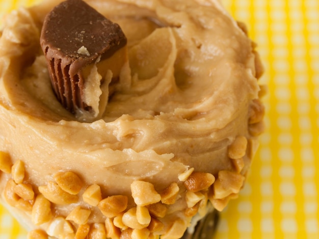 Gourmet Reese's peanut butter cups cupcake on yellow backround.