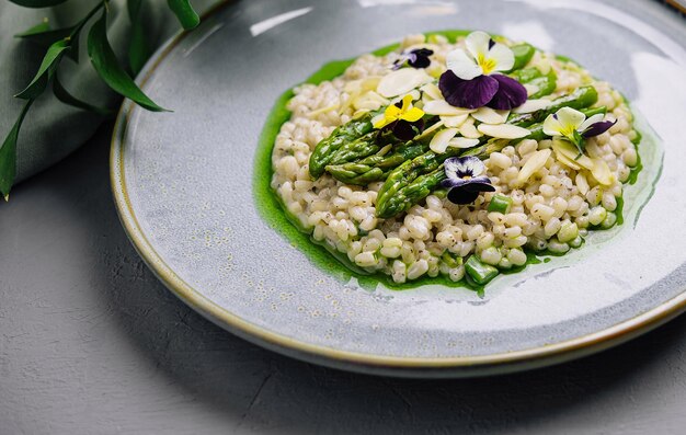 Foto risotto gourmet con asparagi e fiori commestibili