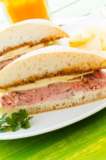 Gourmet roast beef sandwich with chips on the side.