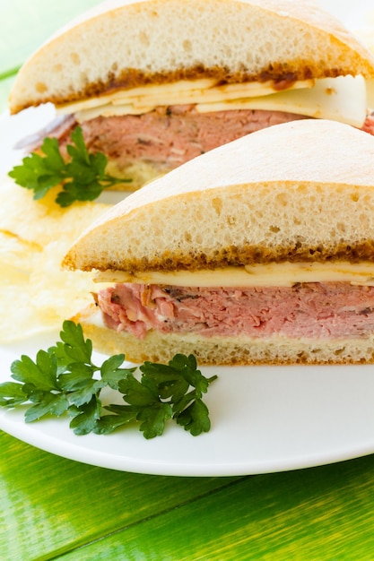 Foto sandwich gourmet di roast beef con patatine sul lato.