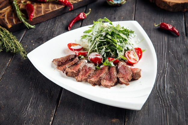 Gourmet roast beef with arugula and tomato salad