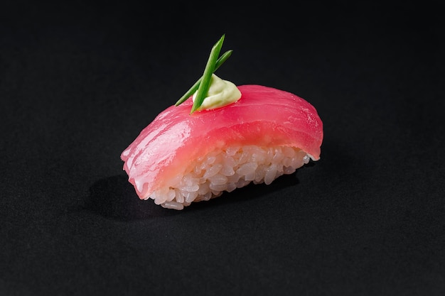 Gourmet tonijn nigiri sushi met wasabi op zwarte achtergrond