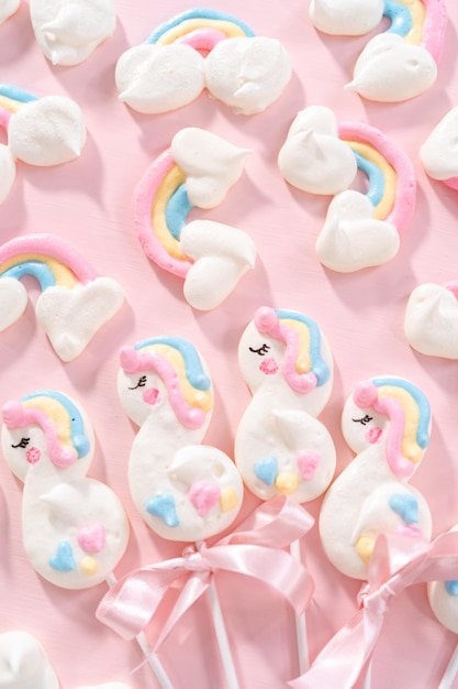 Gourmet unicorn theme meringue pops on a pink background.