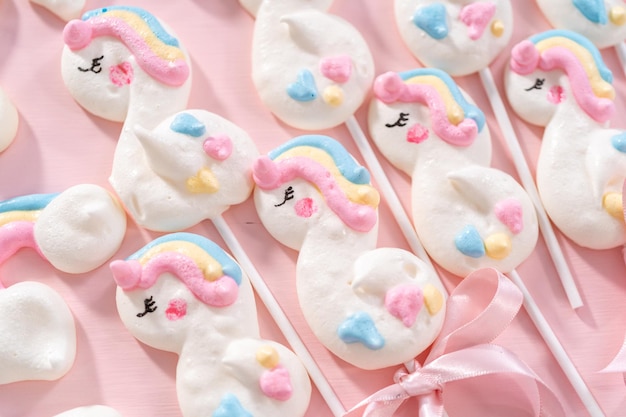 Gourmet unicorn theme meringue pops on a pink background