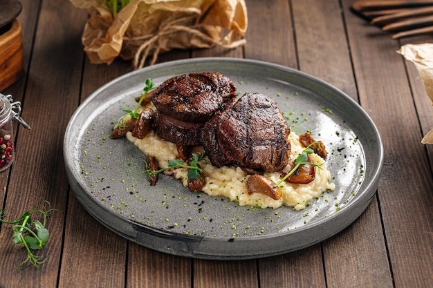 Gourmet veal medallions with risotto on wooden background