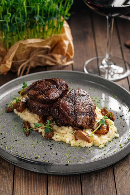 Gourmet veal medallions with risotto on wooden background