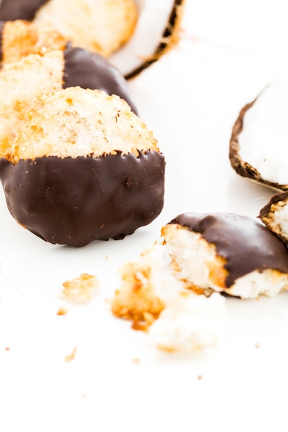 Gourmet white dipped in dark chocolate coconut macarons.