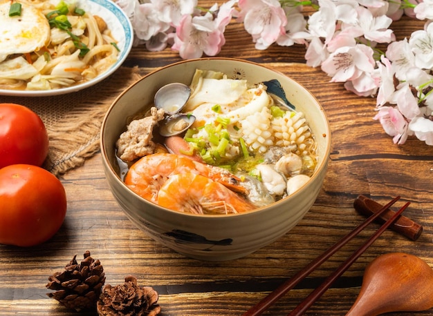 Gout Hot Pot Noodles with tomato and chopsticks served in dish on wooden table top view of chines food