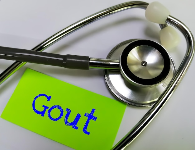 Gout medical term word in green card on white background with stethoscope. medical concept