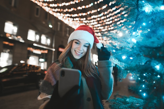 Gportrait donna che indossa il cappello della santa tenendo selfie