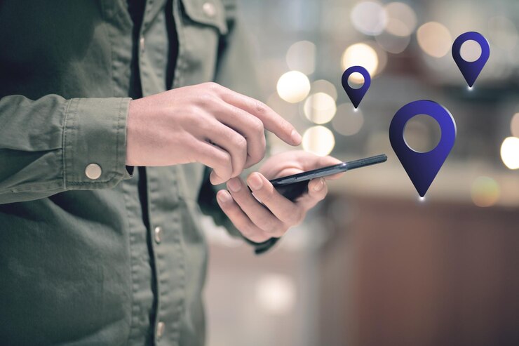 Фотография человек со значком gps держит телефон в руке