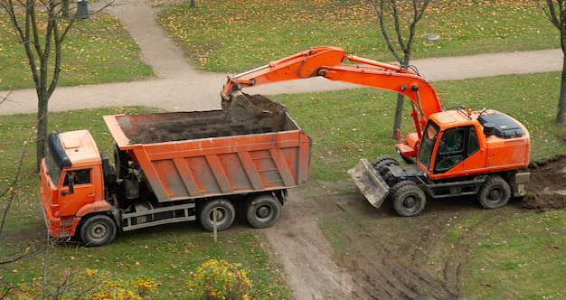 Foto graafmachine en kiepwagen. werk aan de opstelling van tracks.