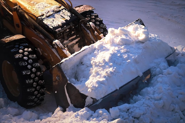 Foto graafmachine met een volle emmer sneeuw sneeuwruimen van stadsstraten 's nachts