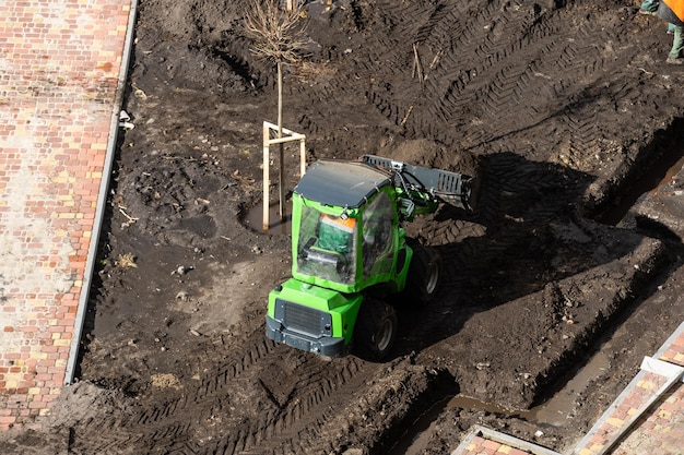 Graafmachine tijdens grondverzet op bouwplaats. ?bouwmachines voor het graven. Torenkranen die een betonnen emmer optillen voor het storten van beton in de bekisting