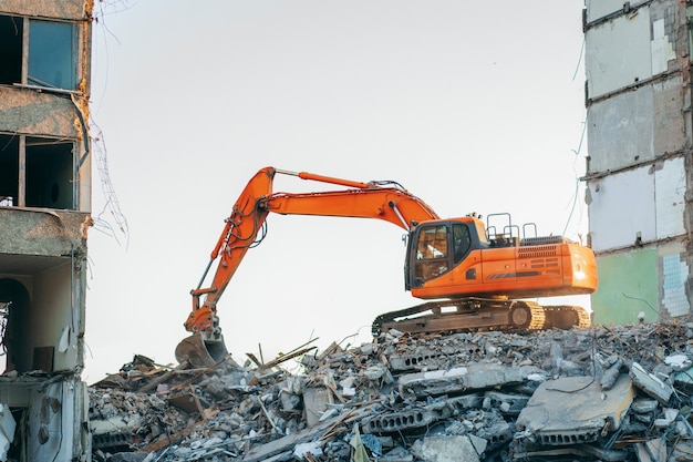 Graafmachine vernietigt een oud gebouw in de stad