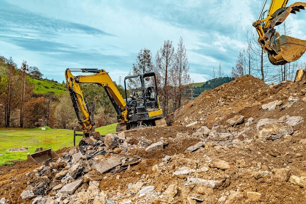 Graafmachines in steengroeven voor de winning van natuurlijke bouwmaterialen achtergrond blauwe hemelbergen