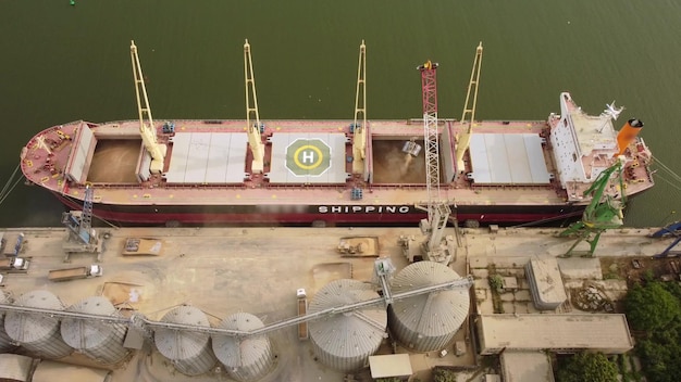 Graan laden in zeevrachtschip in zeehaven vanuit silo's van graanopslag Luchtfoto